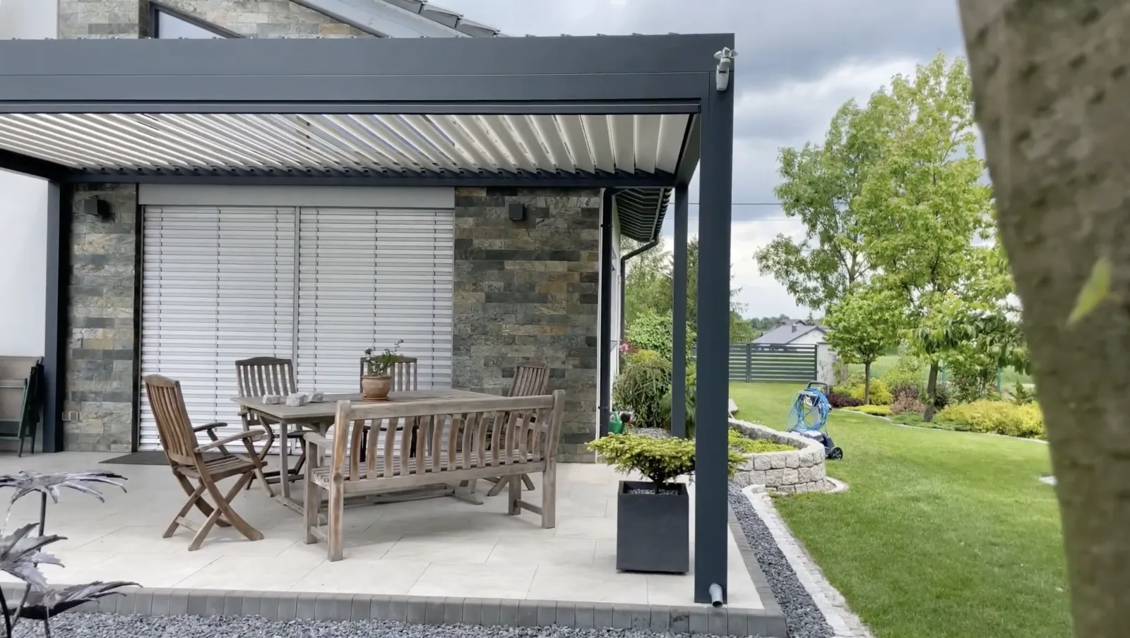 Aluminium wall-mounted pergola creating a sheltered lounge area attached to a Dublin home